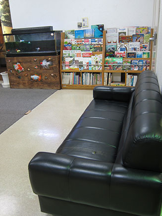 展示室入口手前にはソファが。棚にある本は閲覧自由。
