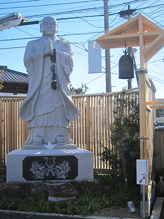 日蓮宗の宗祖である日蓮聖人の石像と、世界平和を祈る鐘。