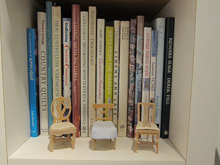 本棚には洋書、手前にはミニチュアの椅子が並ぶ。