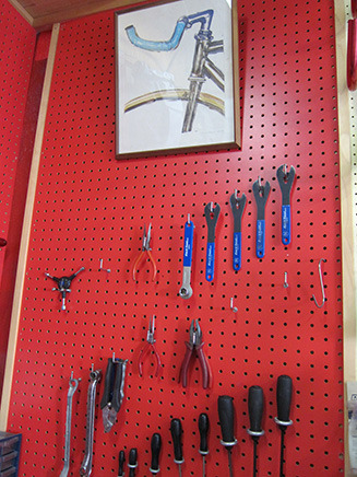 奥の壁には、自転車を修理するための工具が並ぶ。