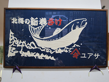 店の看板商品“新巻き鮭”が描かれた布が印象的。