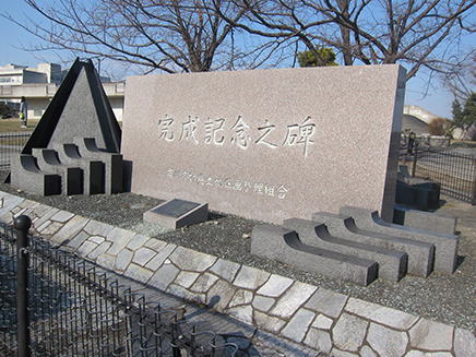 木が植えられた一角に「完成記念之碑」がある。