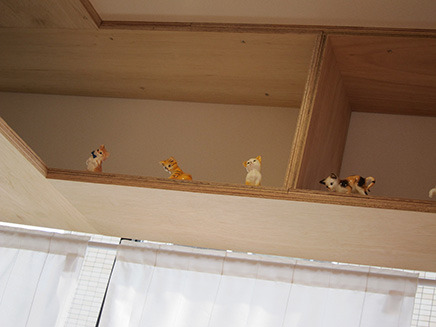 店内を見上げると、キャットウォークをイメージした棚に猫の置物が並ぶ。