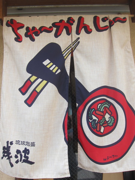 沖縄県と鹿児島県の奄美群島で主に使われている「三線」が描かれた暖簾が目印。