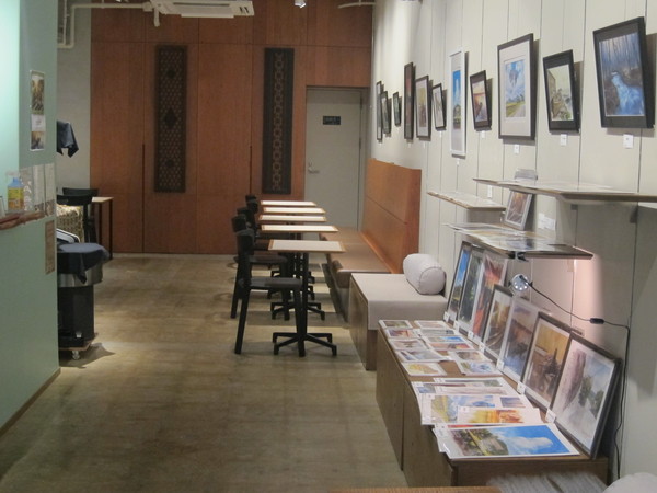右側はベンチシートとテーブル席。個展会開催中は作家さんのグッズも販売。