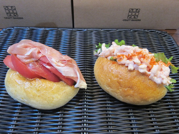 「フォカッチャサンド イベリコ豚の生ハムとトマトのサンド」(左)は、イベリコ豚の生ハムとトマトの最強の組み合わせのサンドイッチ。トリュフオイルがアクセントになっている。「フォカッチャサンド 大漁小エビサンド」(右)は、たっぷりの小エビを定番のオーロラソースにからめたサンドイッチ。エビ好きも大満足の逸品。