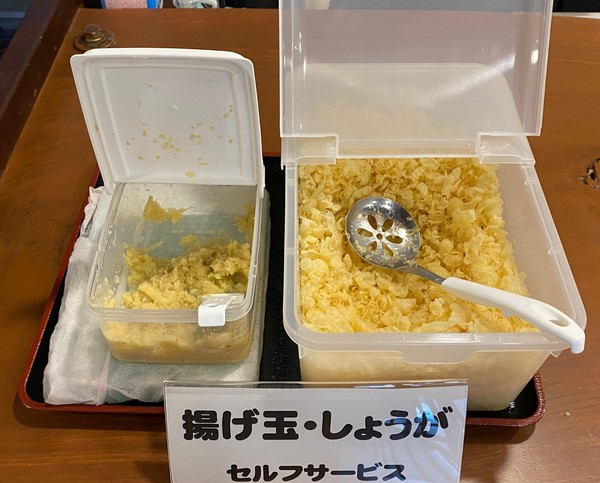注文番号を呼ばれたら受け取り口へ。好みで「揚げ玉」と「しょうが」を自分の器にトッピング。