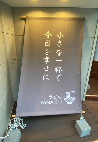 “小さな一杯で今日を幸せに”の幟が目印。