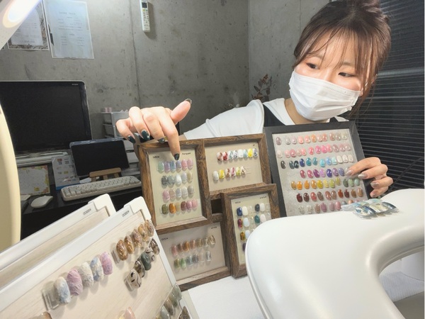 たくさんあるカラー見本の中から提案し、個々のお客様にオリジナルのネイルを作りあげる。