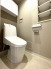 吊戸棚と壁にも収納箇所を用意した節水型トイレ